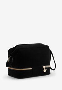 Borsa cosmetica in velluto nero di forma rettangolare, con cerniera dorata e un ciondolo a forma di stella sulla cerniera.