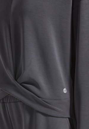 Donkergrijze stof met een gladde textuur, voorzien van een gedraaide ontwerp bij de taille en een klein logoaccent in een zilverkleurige tint.