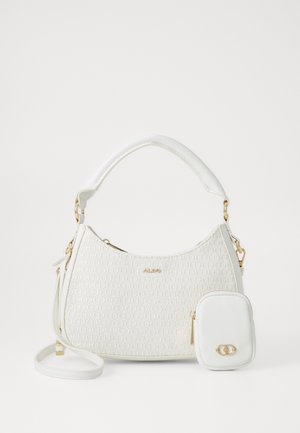 White handbag made of textured material with gold hardware. It features a curved shape, a short handle, and a detachable small pouch.