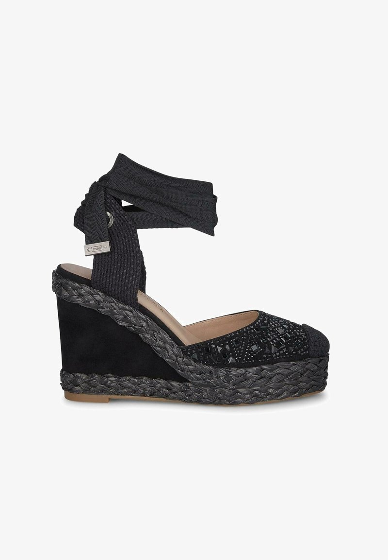 Espadrilla con zeppa nera caratterizzata da una tomaia in tessuto texturizzato, dettagli decorativi con perline e una suola in juta intrecciata. Includerà anche un cinturino alla caviglia regolabile.