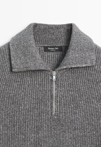 Pull en tricot gris avec un col haut et une fermeture éclair à mi-hauteur. Présente une texture côtelée et une étiquette à l'intérieur avec "Massimo Dutti."