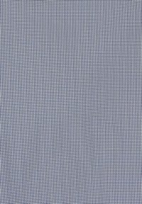 Geometisch stof met een herhaald driehoekig patroon in het wit op een marineblauwe achtergrond, wat een textuureffect geeft.