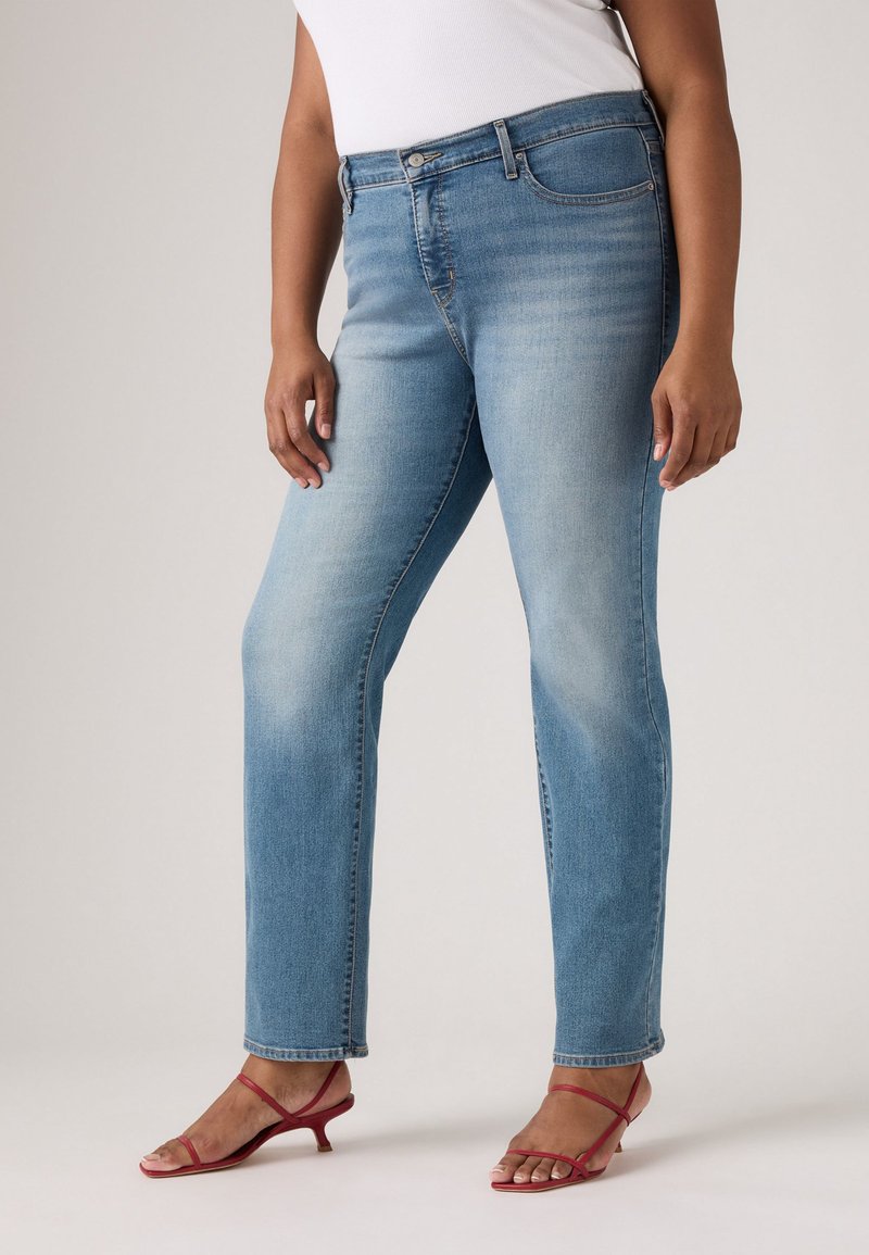 Lyseblå, rette jeans laget av denim, med en falmet finish og femlommedesign. Kombinert med røde sandaler med stropper.