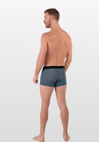 Boxerské trenýrky s černým elastickým pasem a modro-černým vířivým vzorem, vyrobené z měkké, elastické látky.