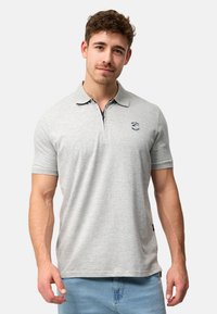 Grå polo t-shirt med krave og korte ærmer, med et lille broderet logo på brystet og en glat, blød tekstur.