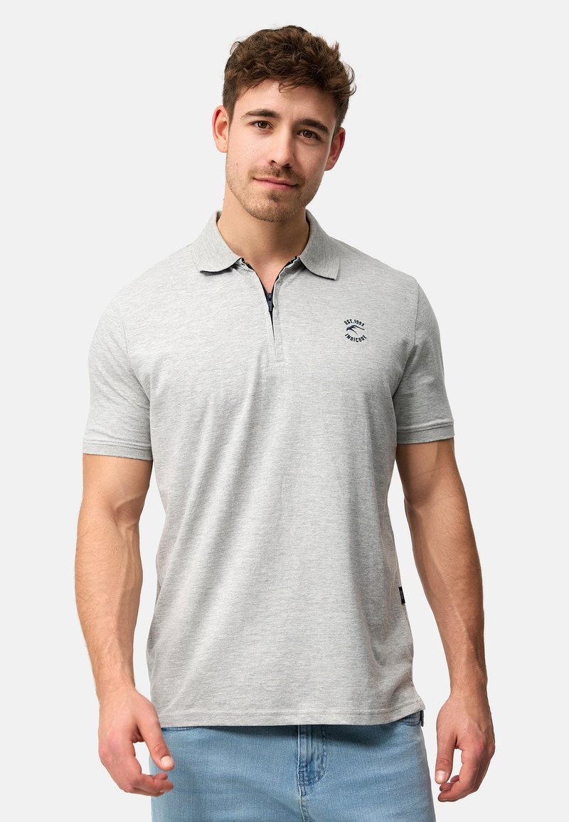 Grå polo t-shirt med krave og korte ærmer, med et lille broderet logo på brystet og en glat, blød tekstur.