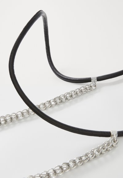 Black leather strap with silver metal chain accents, featuring smooth texture and rounded shape, secured with metallic fasteners.