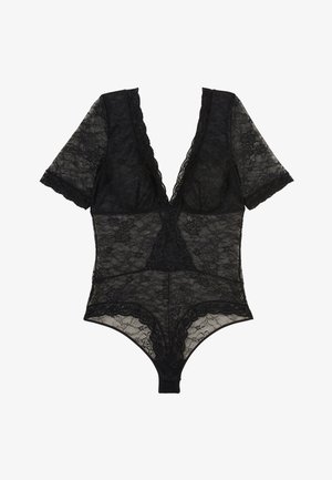 Combinaison en dentelle noire avec des manches courtes, décolleté en V profond, motifs floraux, bords festonnés et fermeture à pression au bas. Matériau translucide.