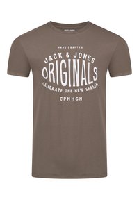 Camiseta de algodón marrón con cuello redondo que presenta un diseño gráfico blanco que incluye el texto "Jack & Jones Originals" y "Celebra La Nueva Temporada."