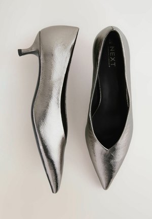 Pantofi cu toc înalt, metalici argintii, cu vârful ascuțit și textură netedă, având un design slip-on și un toc scăzut.