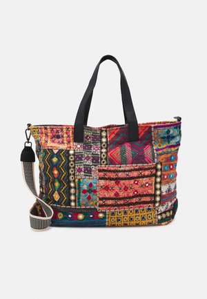 Kolorowa torba patchwork z czarnymi uchwytami i odpinanym czarno-białym paskiem na ramię w paski, zdobiona różnymi haftowanymi wzorami.