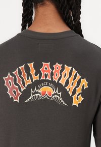 Dark gray cotton sweatshirt featuring a large, colorful graphic with the text "BILLABONG" in a bold, stylized font and a sun motif.