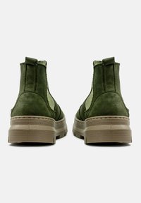 Botas de tobillo de ante verde con paneles laterales elásticos, lengüetas y suelas de goma. Presenta una suela estratificada con textura acanalada.