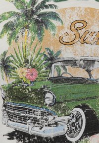 Coche vintage verde con acentos de cromo, rodeado de palmeras y flores tropicales, sobre un fondo texturizado con "Verano" en una fuente estilizada.