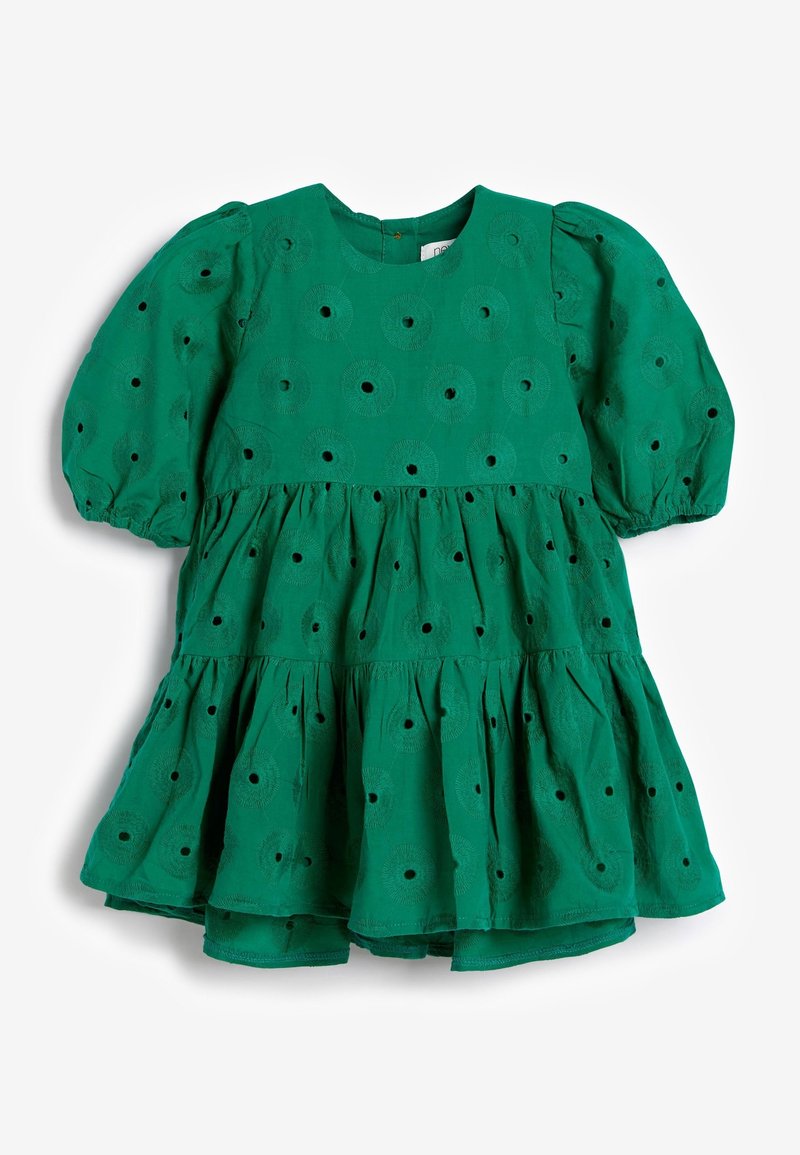 Robe en coton verte avec un col rond, des manches bouffantes et une jupe à volants. Présente des motifs de broderie en œillets sur l'ensemble.