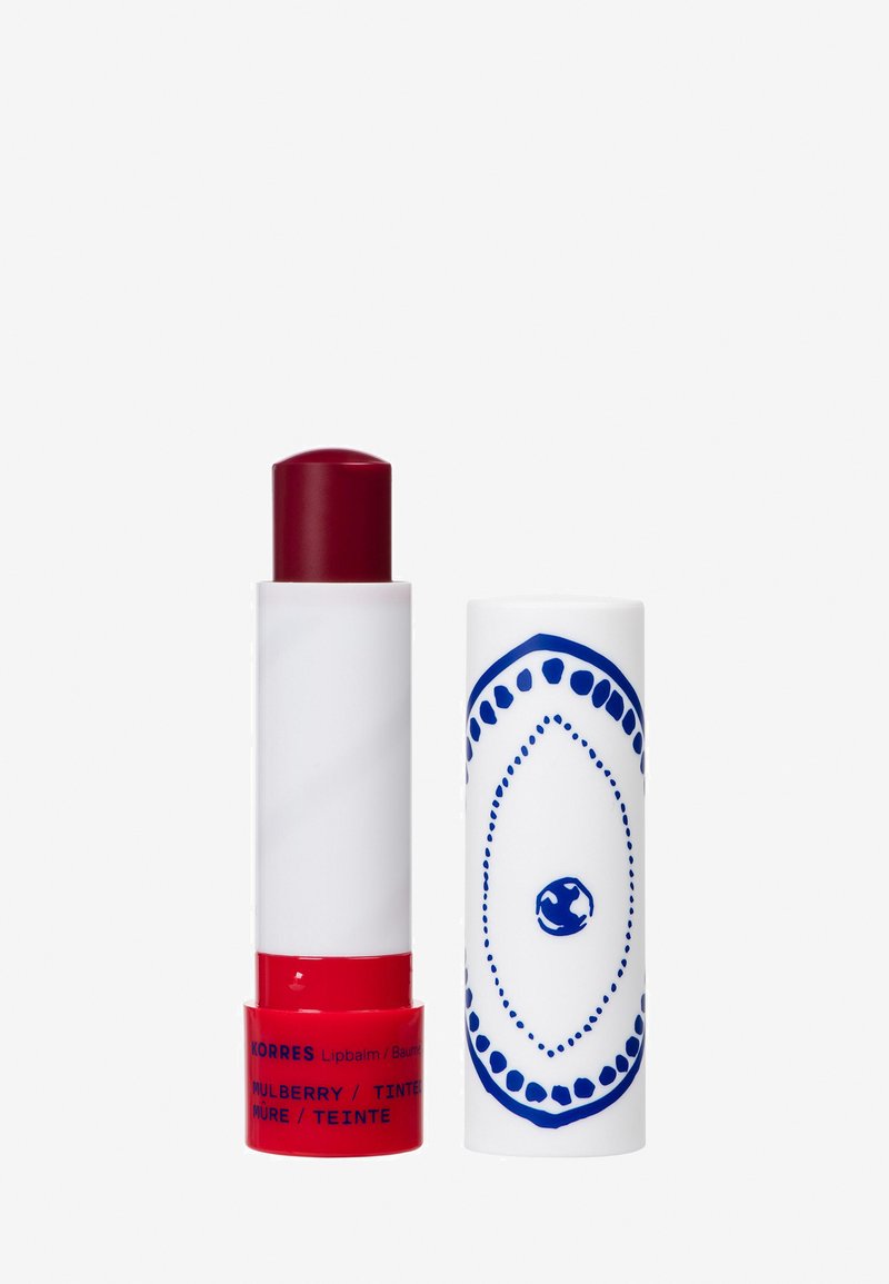 Rood getinte Korres lippenbalsem met witte body en witte dop met blauw decoratief patroon, getoond zonder dop op een witte achtergrond.