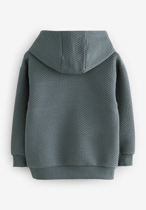Tumman teal-värinen huppari, jossa on teksturoitu timanttikuvio, päällä huppu ja ribbaatut hihansuut sekä helma, nähtynä takaa.