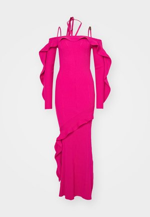 Robe rose ajustée en maille côtelée avec des manches dénudées, des accents volantés le long de l'encolure et de l'ourlet, et des bretelles spaghetti. Texture lisse.