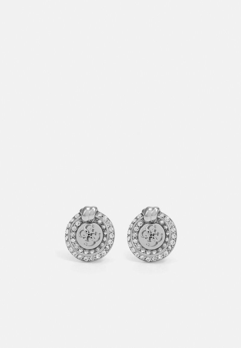Silver circular stud earrings with layered design, featuring a central logo, surrounded by small clear rhinestones. Smooth texture, polished finish.