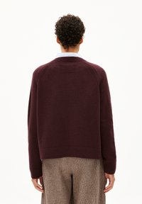Burgunderfarbener Wollpullover mit einem gerippten Kragen und Bündchen, in einer verkürzten Silhouette mit einem strukturierten Rückenteil-Design.