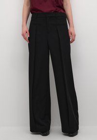 Pantaloni a gamba ampia neri con vita alta, caratterizzati da dettagli plissettati, tasche laterali e una texture morbida e tessuta.