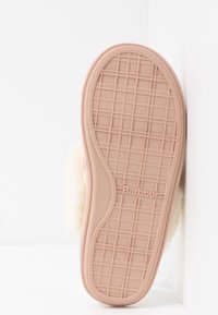 Semelle de chausson rose en caoutchouc avec motif de semelle en grille et logo "Barbour", doublure crème duveteuse visible sur les bords.