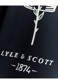 Dunkelblauer Stoff mit weißer und gelber Stickerei eines Blumenmotivs mit Blättern. Enthält "LYLE & SCOTT" und "1874" in Weiß aufgedruckt.