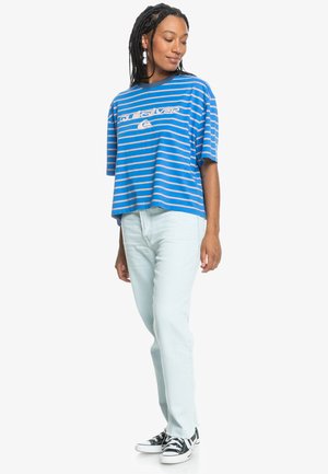 Blue and white striped cotton t-shirt with a logo, paired with light blue jeans and black-and-white sneakers. Relaxed fit and short sleeves.