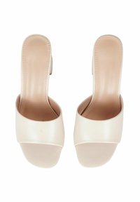 Mule con tacco aperto beige, con tomaia in pelle liscia, ampia fascia sul davanti e tacco leggermente sollevato. Design semplice e minimal.