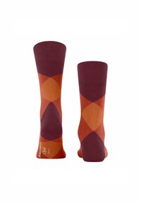 Calze colorate con un motivo a diamante in maroon, arancione e crema, che mostrano vivaci design a contrasto.