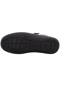 Black rubber shoe sole with a textured surface and multiple vertical and horizontal grooves for traction. Includes a raised brand logo.