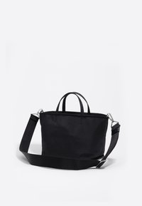 Melnā tote soma, kas izgatavota no izturīga auduma, ar divām augšējām rokturiem, regulējamu plecu siksnu un vienkāršu taisnstūra formu.