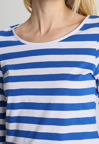 Blau-weiße gestreifte Langarmbluse mit Rundhalsausschnitt, aus weichem Material gefertigt, mit gleichmäßigen Streifen und lockerer Passform.