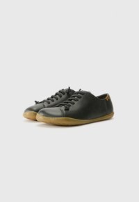 Scarpe nere in pelle con finitura texturizzata, punta rotonda e suola in gomma. Presentano lacci scuri e un piccolo accento marrone sul tallone.