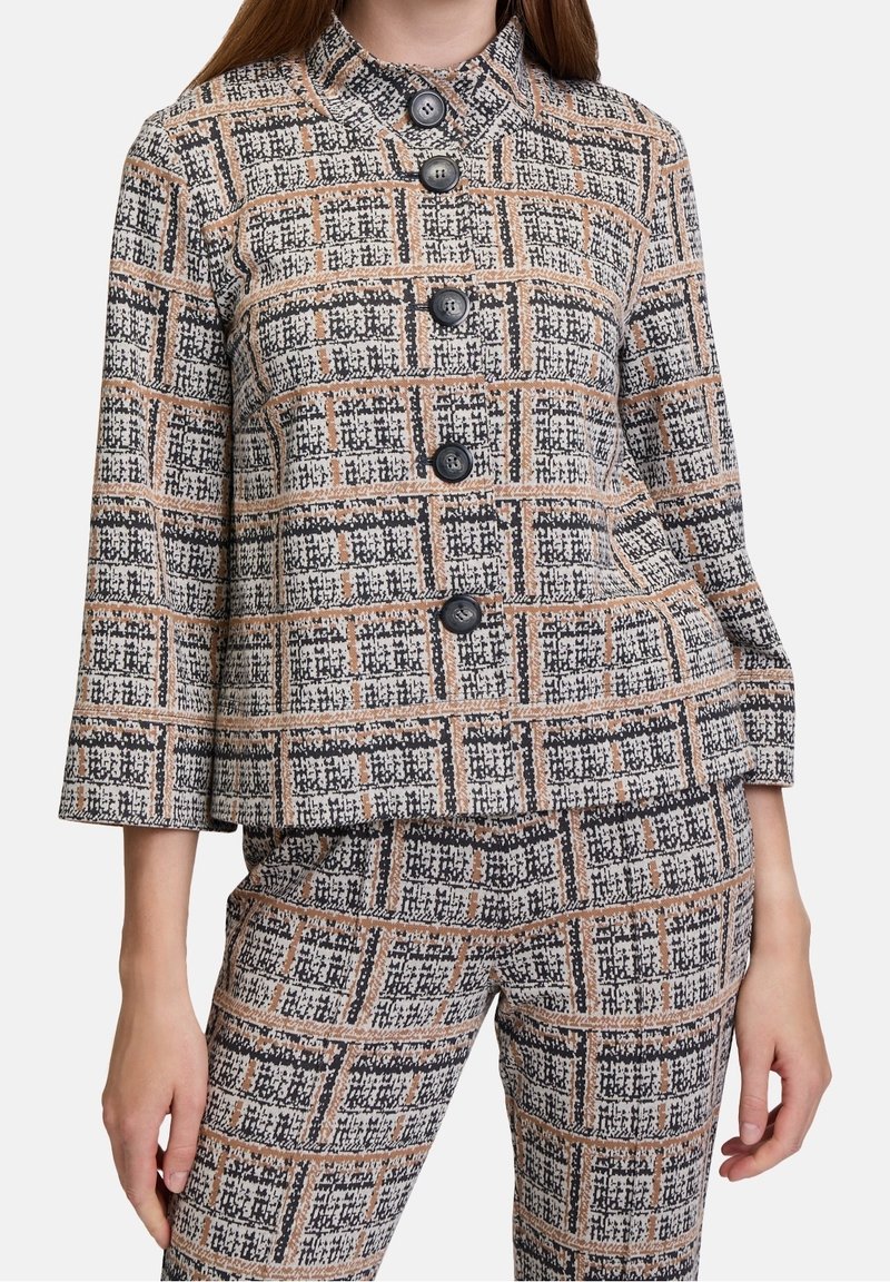 Vävd kavaj i ett strukturerat tyg med ett rutmönster i beige, svart och rostfärger, med sex svarta knappar och kinesisk krage.