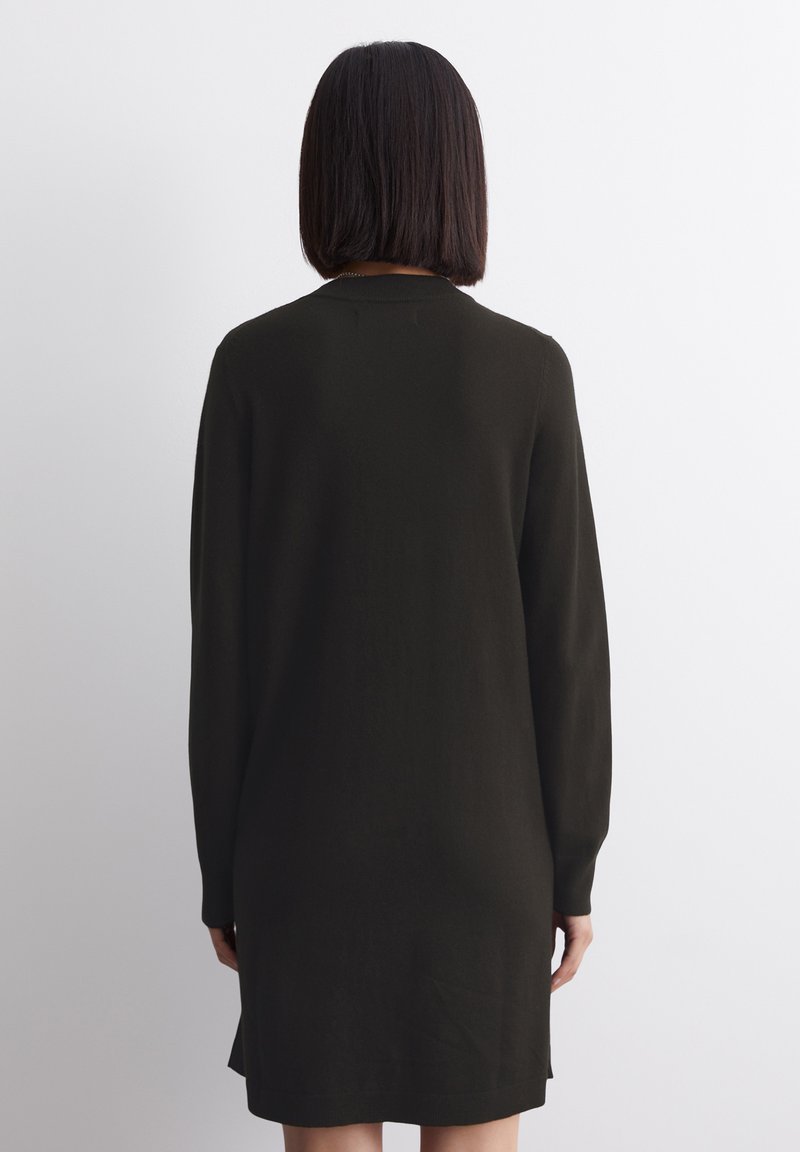 Dunkelgrünes, langärmliges Kleid mit lockerer Passform, knielangem Schnitt, glatter Textur und rundem Ausschnitt. Schlichtes Design mit seitlichen Schlitzen.