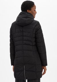 Zwarte pufferjas met capuchon, voorzien van een gewatteerd design, ritssluiting aan de achterkant en een rechte snit. Mid-lange lengte.