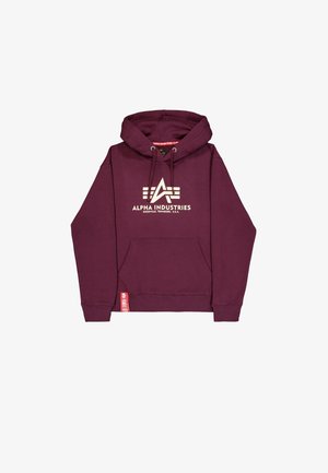 Karmiinpunane kapuutsiga dressipluus esi-taskuga, pingutustrossiga kapuuts ja "Alpha Industries" logo heledas beežis. Küljel on väike punane silt.