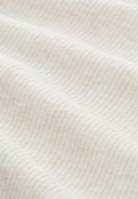 Biała, prążkowana tkanina o miękkiej fakturze, z delikatnymi liniami tworzącymi falisty wzór na powierzchni. Gładka i lekka.