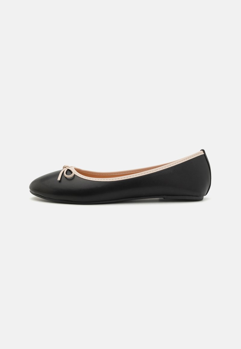 Ballerine noire en matériau synthétique, avec un bout arrondi, un contour de couleur claire contrastante, et un petit nœud sur le devant.