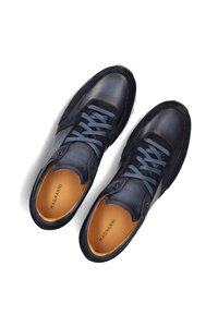 Navy leather and suede sneakers with a textured finish, featuring blue laces, a rounded toe, and a tan insole printed with "MAGNANNI."