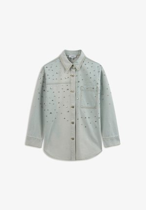 Light blue denim shirt with a button front, long sleeves, and silver stud embellishments across the front and pocket.