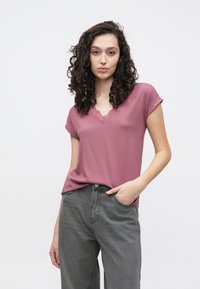 Κοντομάνικη μπορντό μπλούζα με V-λαιμόκοψη διακοσμημένη με δαντέλα, συνδυασμένη με γκρι ψηλόμεσα τζιν. Μαλακό ύφασμα με άνετη εφαρμογή.