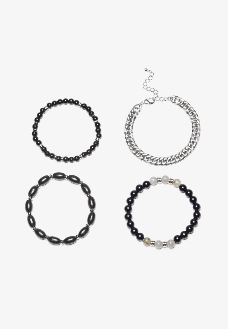 Cuatro pulseras: una de cadena de plata y tres de cuentas en negro, con diferentes tamaños y texturas de cuentas. Dos incluyen acentos de plata y una tiene cuentas de color claro.