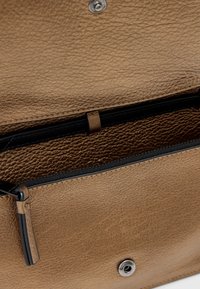 Portafoglio in pelle bronzea con superficie texturizzata, dotato di un interno nero, chiusura a scatto magnetico e scomparto con zip per una conservazione sicura.