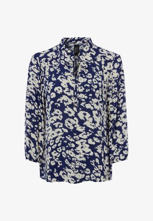 Blouse bleu marine à manches longues avec imprimé floral abstrait blanc et petit col à volants noué au niveau de l'encolure.