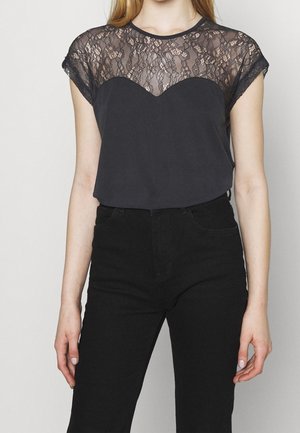 Black short-sleeve top featuring a lace yoke design and a smooth, fitted body. The lace has a floral pattern, contrasting with the solid fabric.