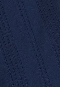 Tessuto blu navy con una trama liscia, caratterizzato da linee cucite verticalmente per i dettagli e una leggera lucentezza nel materiale.