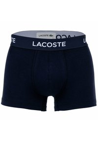 Tengerszínű boxer alsónadrág puha pamut anyagból, fehér Lacoste logóval ellátott derékpánttal és szoros, enyhén fazonra szabott kialakítással. Minták vagy díszítések nélkül.