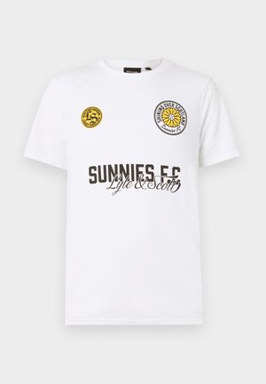 Bela bombažna majica s krožnim izrezom. Ima rumene in črne krožne logotipe na prsih ter besedilo "SUNNIES F.C." v rjavi barvi.
